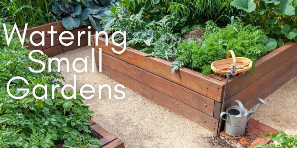 Garden beds in small vegetable garden with a watering can and outdoor hose faucet