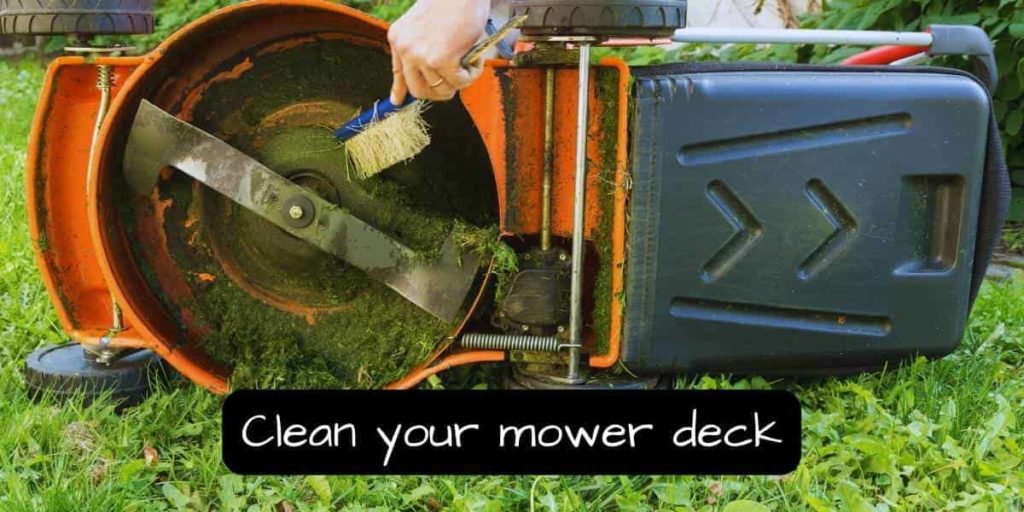 cleaning a mower deck using a brush and a hose